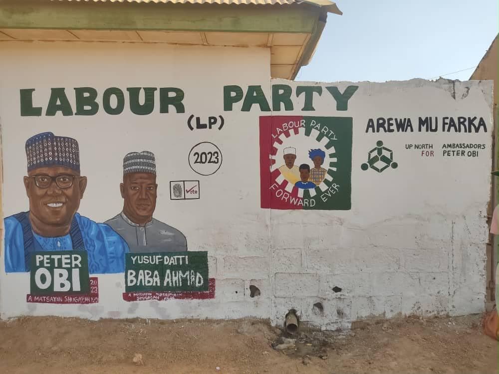 A hand-painted “Arewa Mu Farka” mural on a community wall.