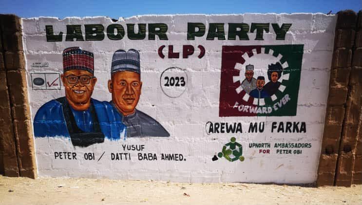 A campaign mural painted onto a mud-brick wall.