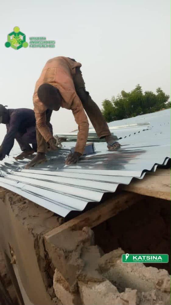 New roofing sheets being fixed across the rebuilt structure.